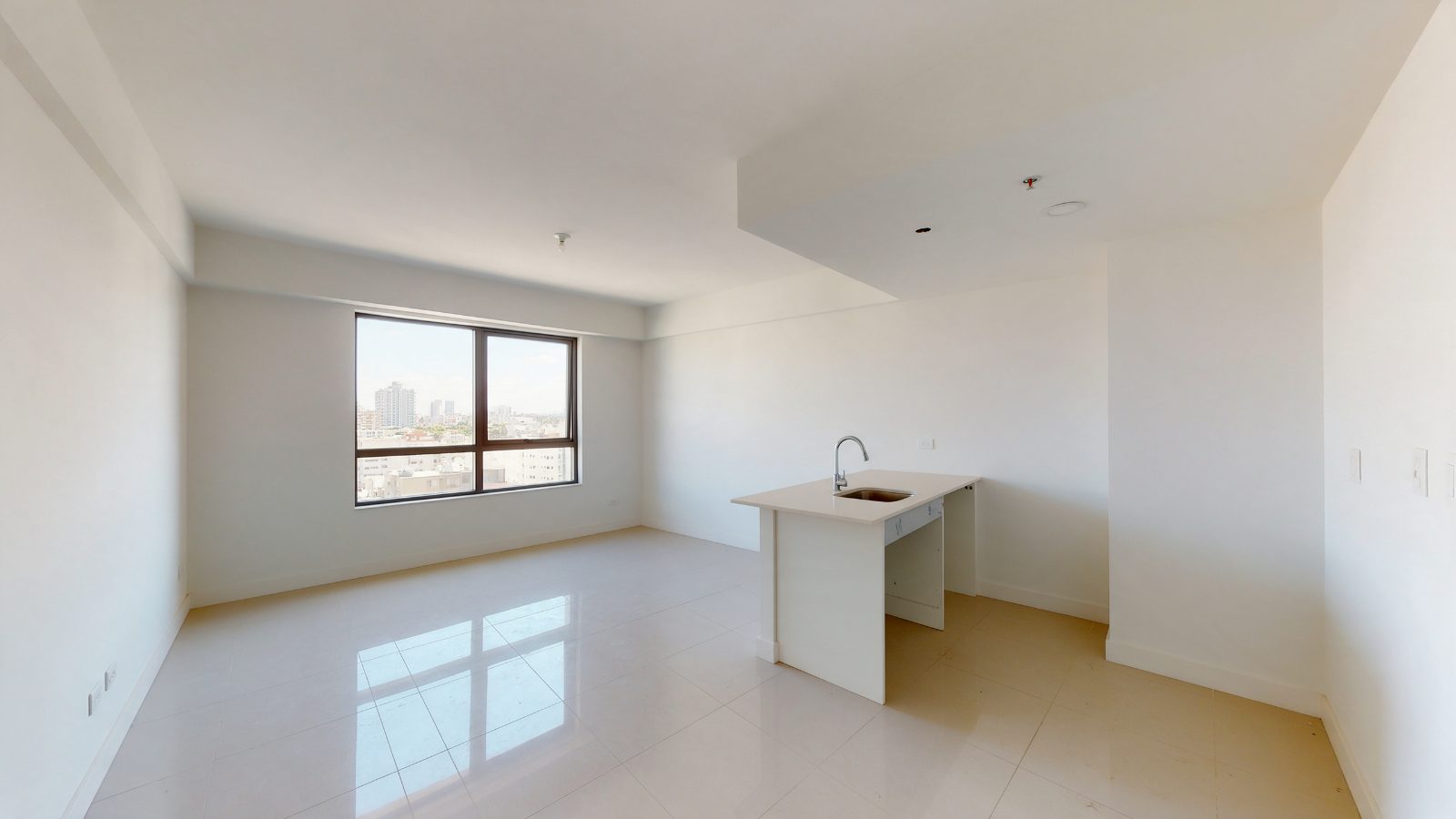 Studio recém-entregue sem mobília, com piso claro e janela ampla